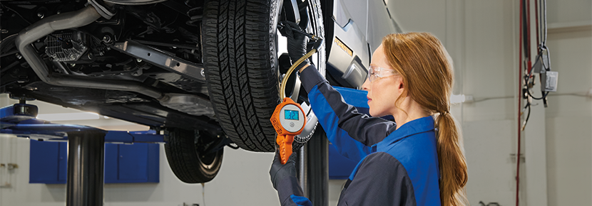 A Subaru technician checking tire pressure. | Dulles Motorcars Subaru in Leesburg VA