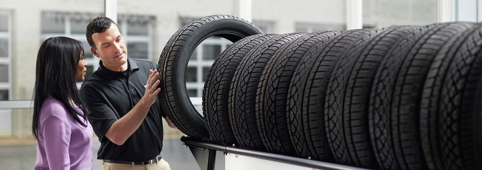 Subaru service representative showing customer a tire. | Dulles Motorcars Subaru in Leesburg VA
