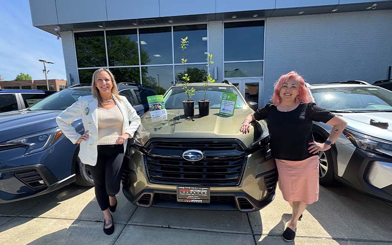 Employees standing next to car